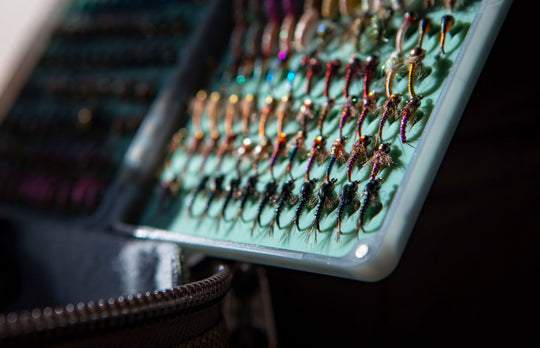 Angler choosing a fly from the Fishpond Tacky Original 2X Fly Box